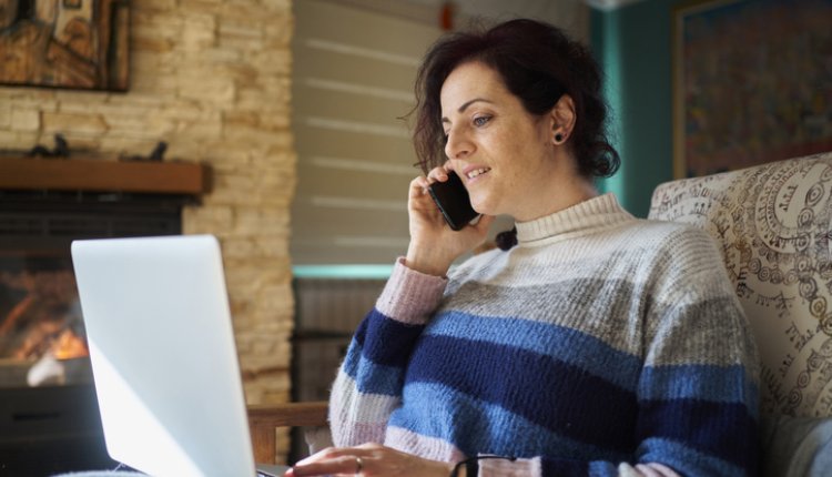 Vrouw zit op de bank met laptop