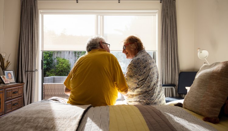Man en vrouw zitten op rand bed