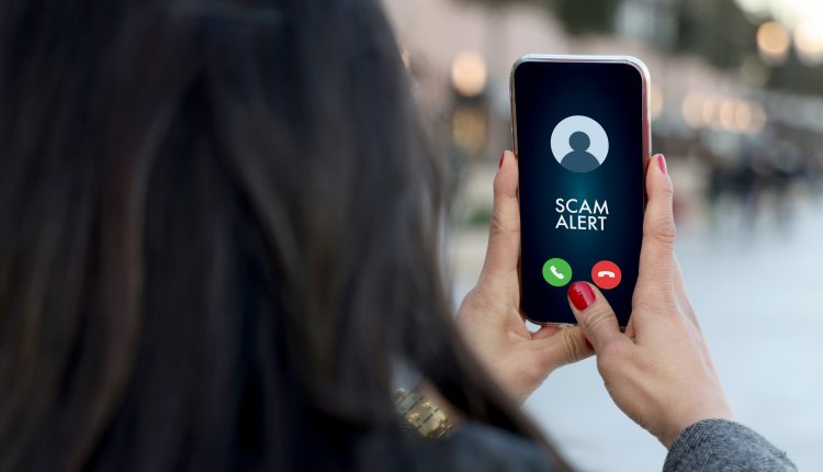 Vrouw met tekst Scam Alert op haar smartphone, phishing en oplichting