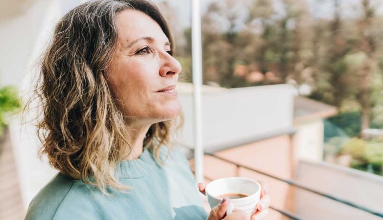 Vrouw mijmert met kop thee