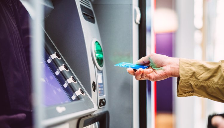 Vrouw pint geld uit betaalautomaat