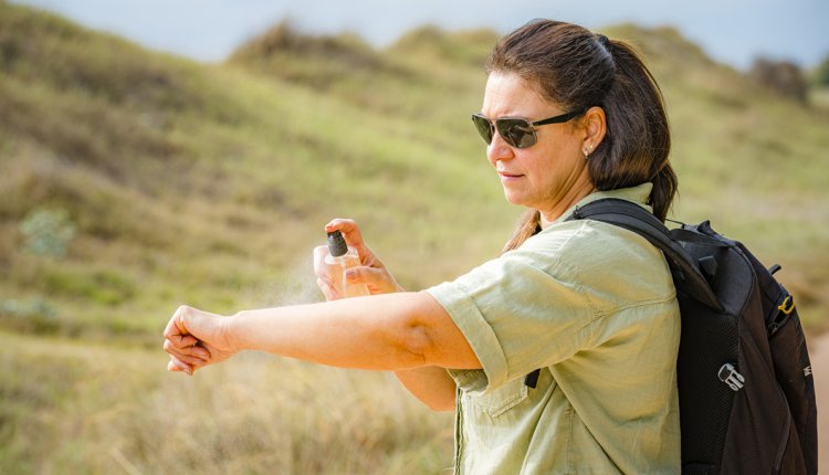 oudere vrouw spuit zich in tegen insectenbeten