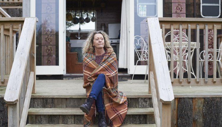 Vrouw zit peinzend op veranda