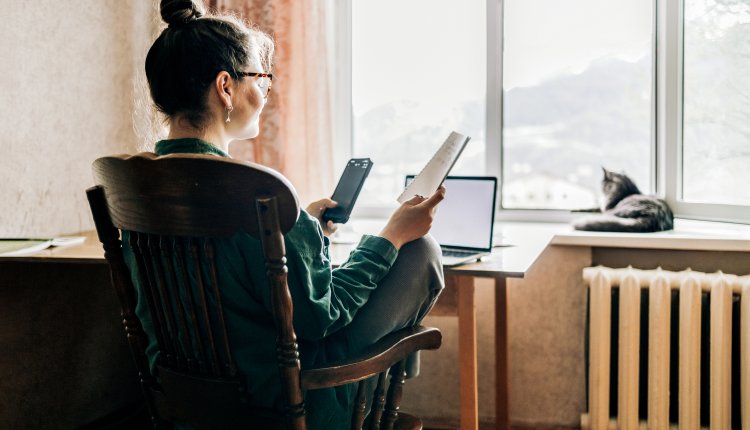 Vrouw is thuis aan het werk, kat op de vensterbank