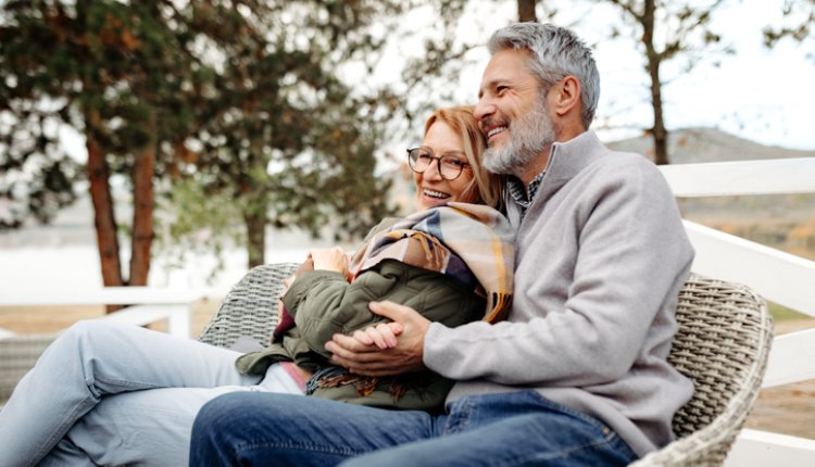 Ouder koppel poseert op een bank in het park
