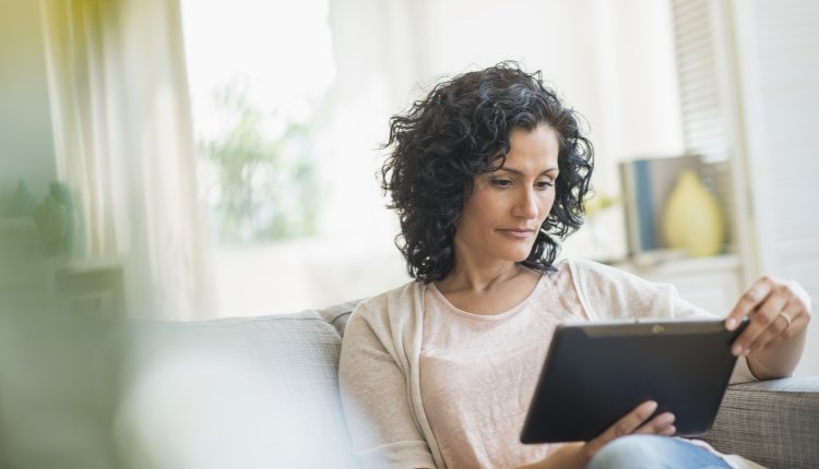 Vrouw met tablet op de bank