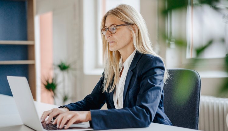 Werkende vrouw achter laptop