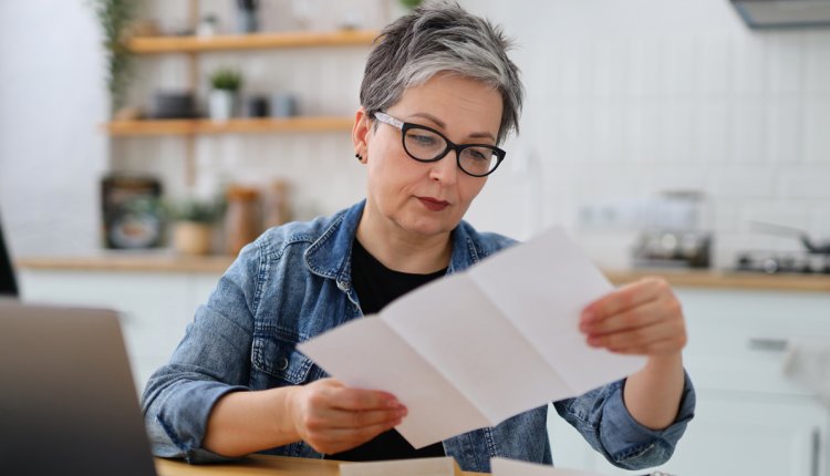 oudere vrouw bekijkt lijst op papier