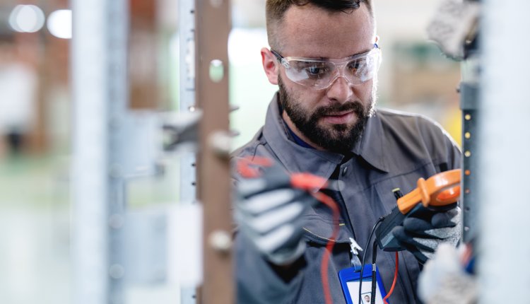 Mannelijke electricien fikst stroomnet