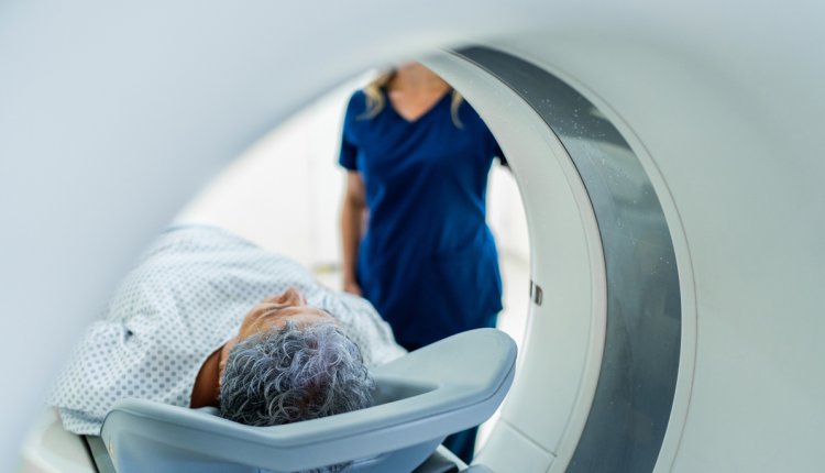 man in een mri-scan begeleiding van verpleegkundige