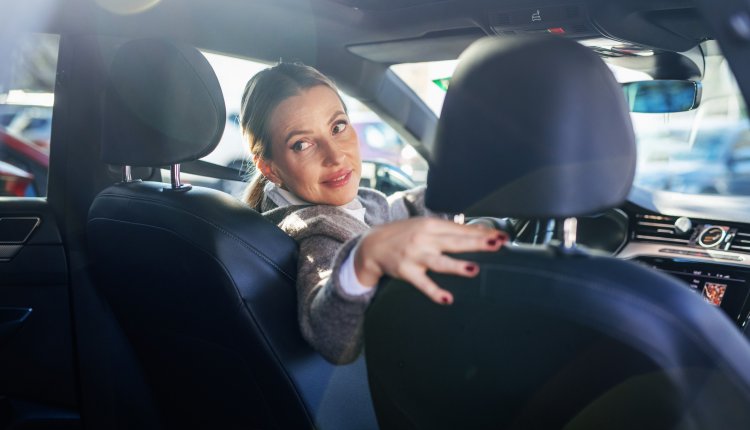 Vrouw in auto probeert achteruit in te parkeren