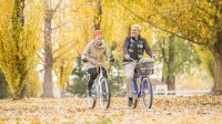 Fietsende mensen in een herfstbos