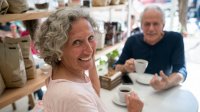 ouder echtpaar drinkt een kopje zwart koffie aan een tafel