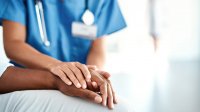Verpleegkundige houdt hand vast van patiënt