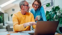 Hypotheek ouder paar bespreekt de cijfers met laptop