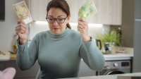 Vrouw met bankbiljetten in de hand controleert status van haar hypotheek