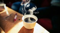 Een kop koffie op tafel in de zon