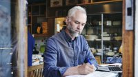 Man is bezig met schrijven in zijn workshop