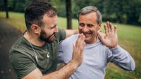 Vader en zoon trainen samen buiten en geven een high 5