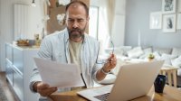 Man is bezig met zakelijke papierwinkel in huiskamer