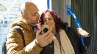 Man en vrouw bekijken telefoon in de bus