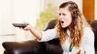 Vrouw is aan het zappen op televisie