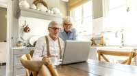 ouder stel aan tafel met computer