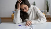 Vrouw bestudeert energierekening met bezorgd gezicht