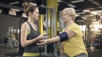 vrouw meet bloeddruk in sportschool