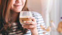 Vrouw aan een kop koffie met eiwitten