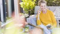 Vrouw eet op terras blauwe bessen