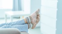 Vrouw met benen omhoog op de bank in warme sokken