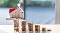 Woningprijs, huisje op een stel gestapelde munten