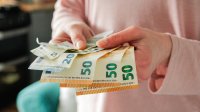 Vrouw met handen vol geldwaaier