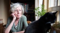 oudere vrouw staart  uit raam