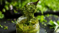 potje groene pesto met een lepel erin