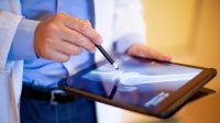 Dokter kijkt naar ipad met artrose foto