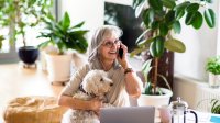 Vrouw met hond voert een vrolijke telefoongesprek