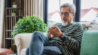 Man zit op de bank zijn zaken door te nemen op smartphone