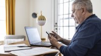 Corpulente man is thuis aan het werk achter zijn laptop