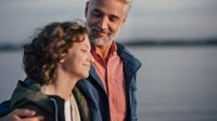 Man wandelt met zijn dochter over het strand