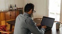 man achter laptop