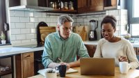 Koppel is in de keuken bezig achter laptop
