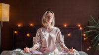 Vrouw doet yoga-oefening op bed voor het slapengaan