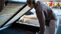Vrouw kijkt naar lattenbodem in winkel voor bedden
