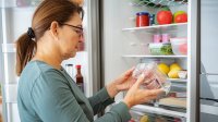 Vrouw checkt houdbaarheidsdatum van een verpakking