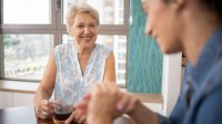 oudere vrouw drinkt koffie met mantelzorger