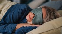 Vrouw ligt te slapen met slaapmasker op