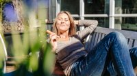 Vrouw zit buiten en eet een wortel