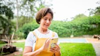 Vrouw met smartphone in de tuin